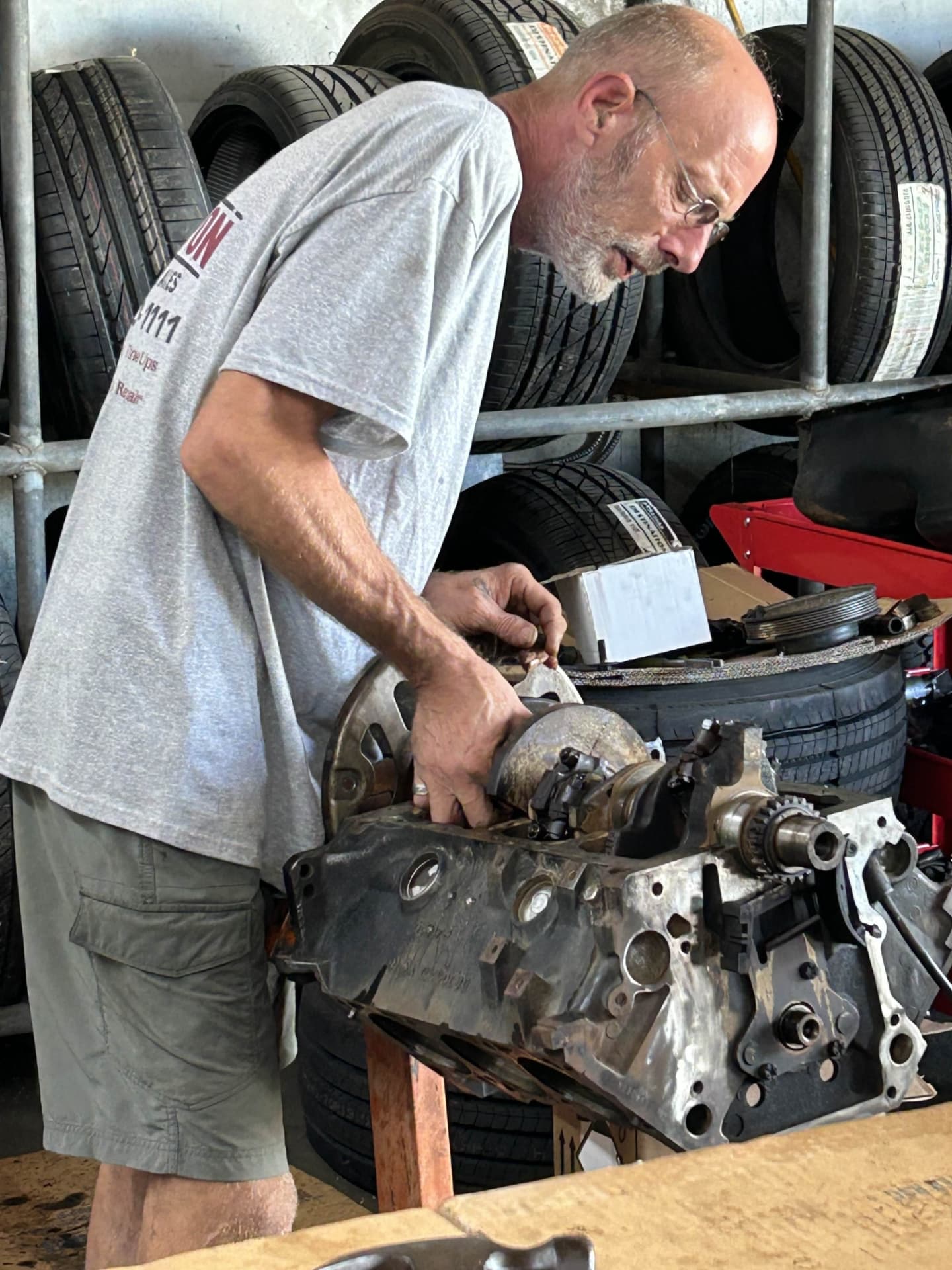 Mechanic rebuilding an engine block at the Champion Tires & Brakes shop on Rivers Avenue
